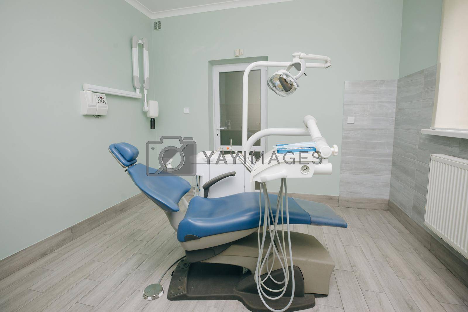 Modern dental practice. Dental chair and other accessories used by dentists in blue, medic light. Dentist Office, Dental Hygiene, Dentist's Chair.