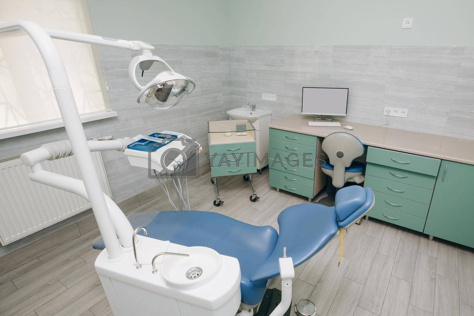 Dentist Office, Dental Hygiene, Dentist's Chair. Modern dental practice. Dental chair and other accessories used by dentists in blue, medic light