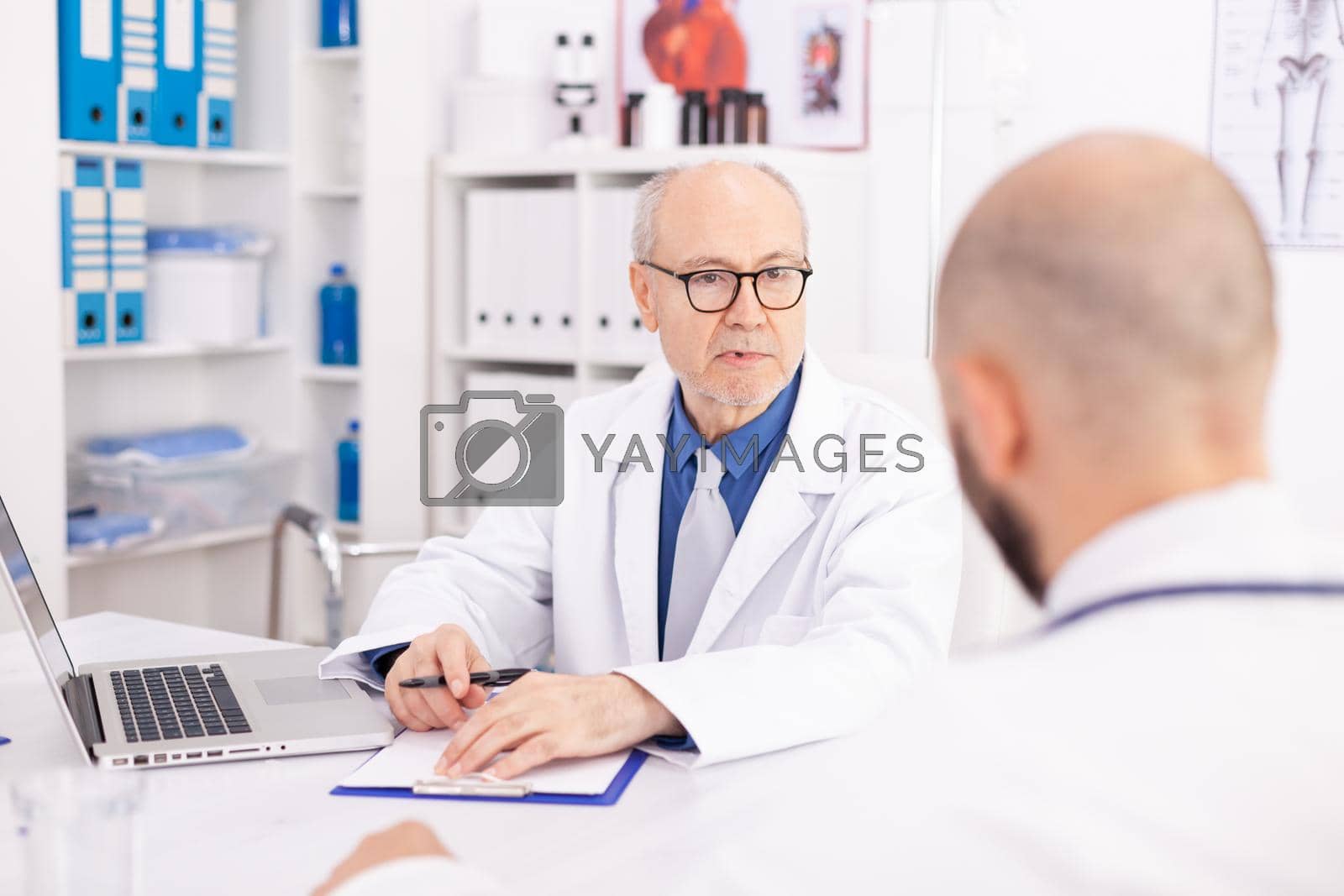 Royalty free image of Experienced mature doctor explaining diagnosis by DCStudio