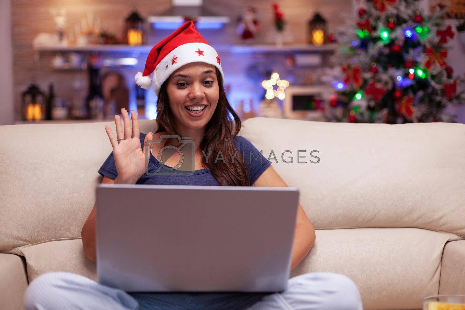 Royalty free image of Smiling woman greeting remote friends enjoying christmastime together by DCStudio