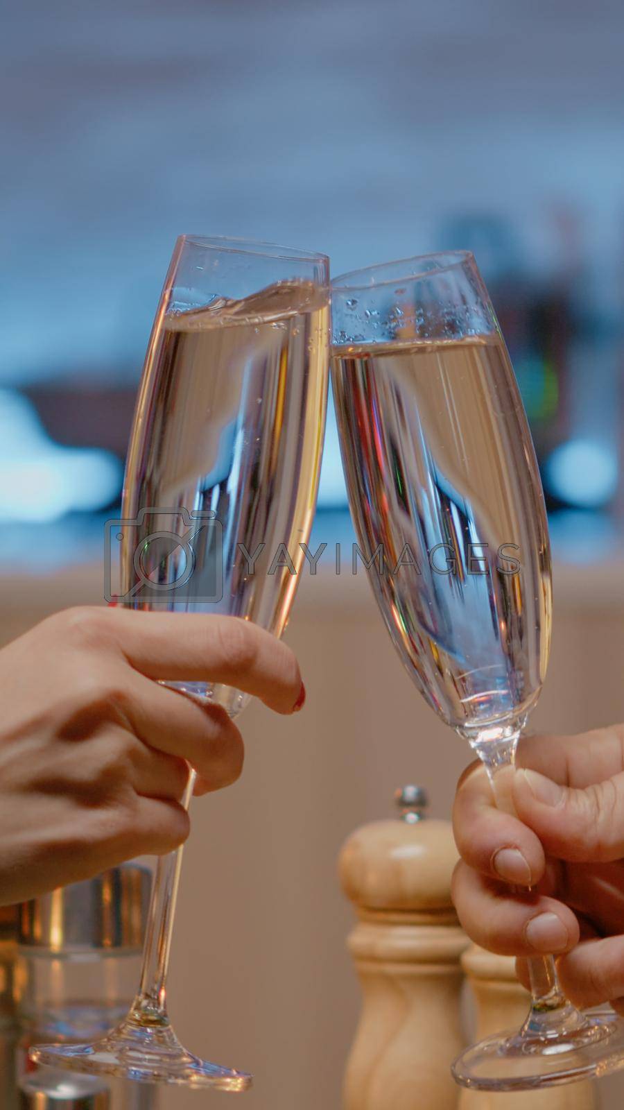 Royalty free image of Close up of couple at festive dinner clinking glasses of champagne by DCStudio