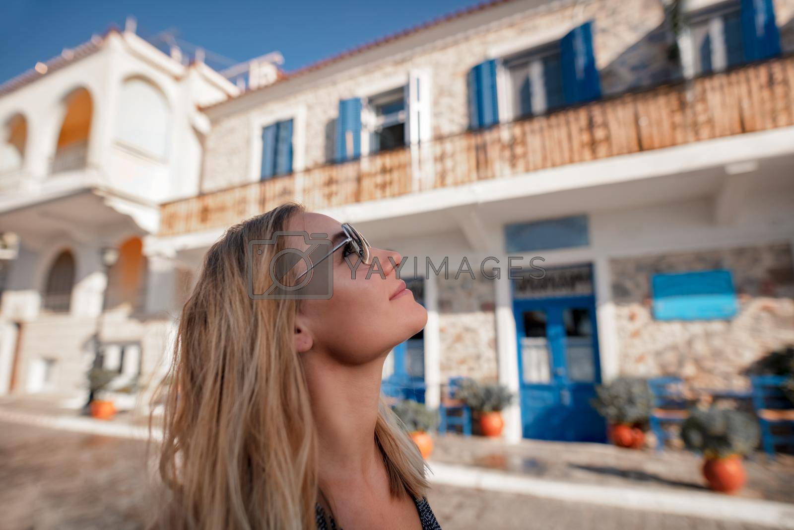 Closeup Portrait of Nice Happy Female Enjoying Bright Sunny Day on Greek Islands. Travel to Greece. Summertime Vacation.