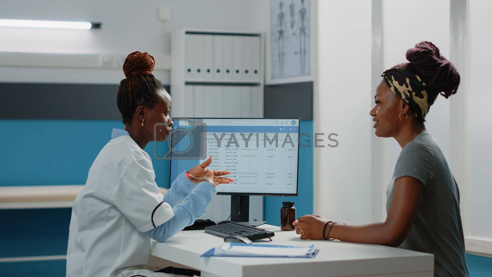 Royalty free image of Doctor talking to patient about physical pain and disease by DCStudio