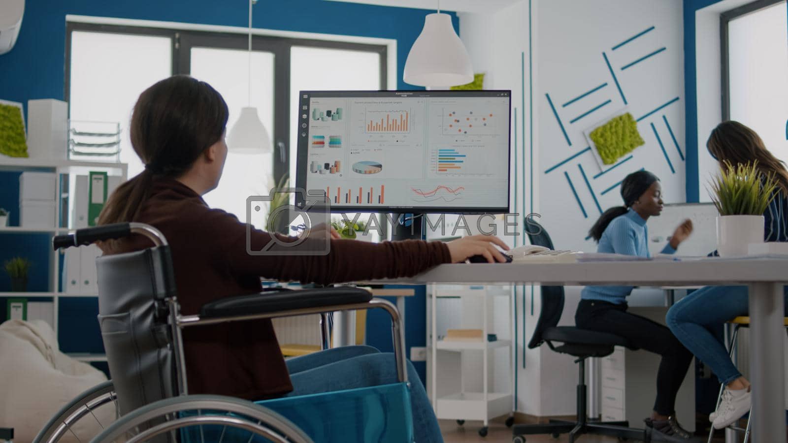 Royalty free image of Handicapped businesswoman analysing financial statistics sitting in wheelchair by DCStudio