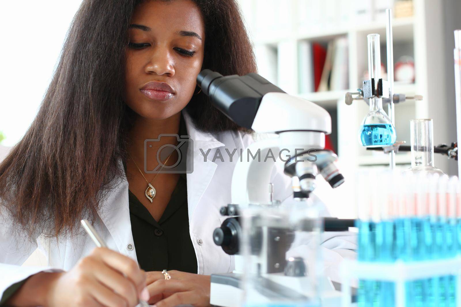 Royalty free image of Black woman scientist student chemist in protective by kuprevich