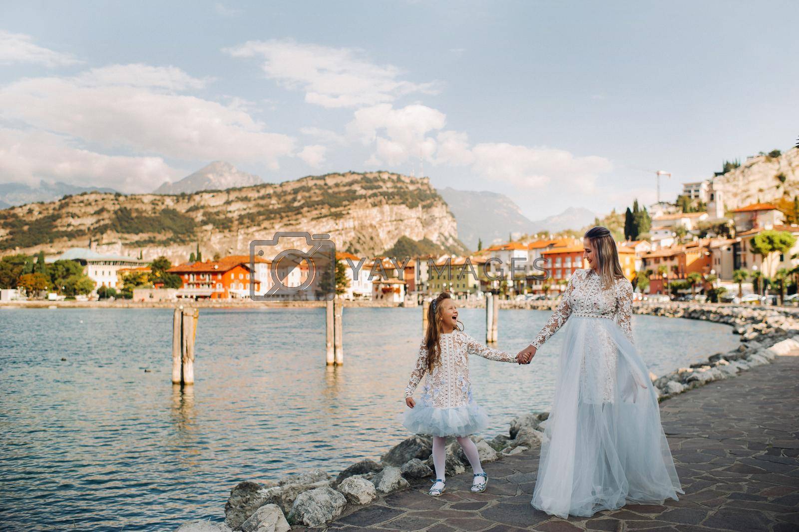 Royalty free image of Italy, Lake Garda.Stylish Mother and daughter on the shores of lake Garda in Italy at the foot of the Alps. mother and daughter in Italy by Lobachad
