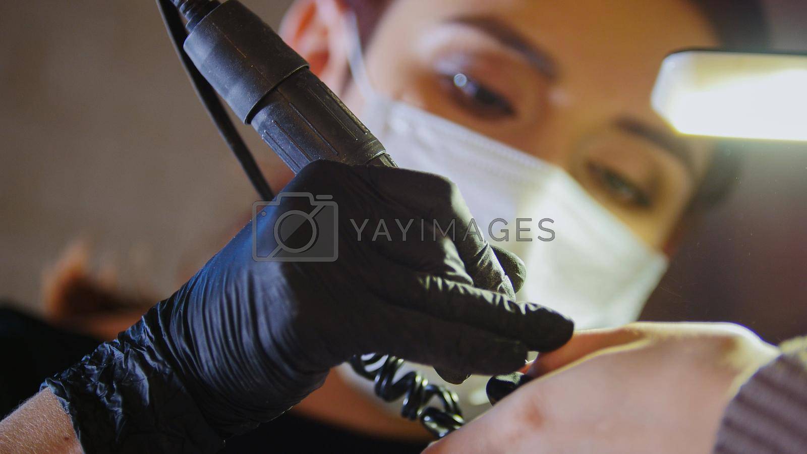 Manicurist in medical mask doing manicure in beauty shop, close up