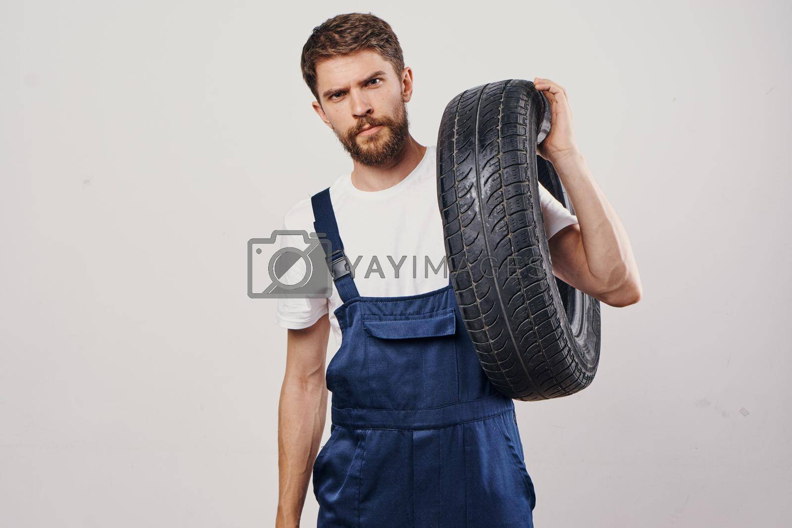 Royalty free image of male worker auto mechanic machine professional light background by Vichizh