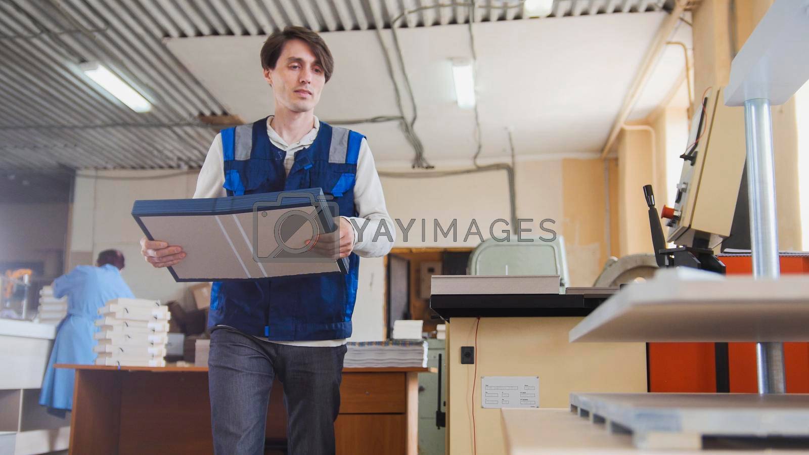 Royalty free image of Printing process - worker inserts paper sheets by Studia72
