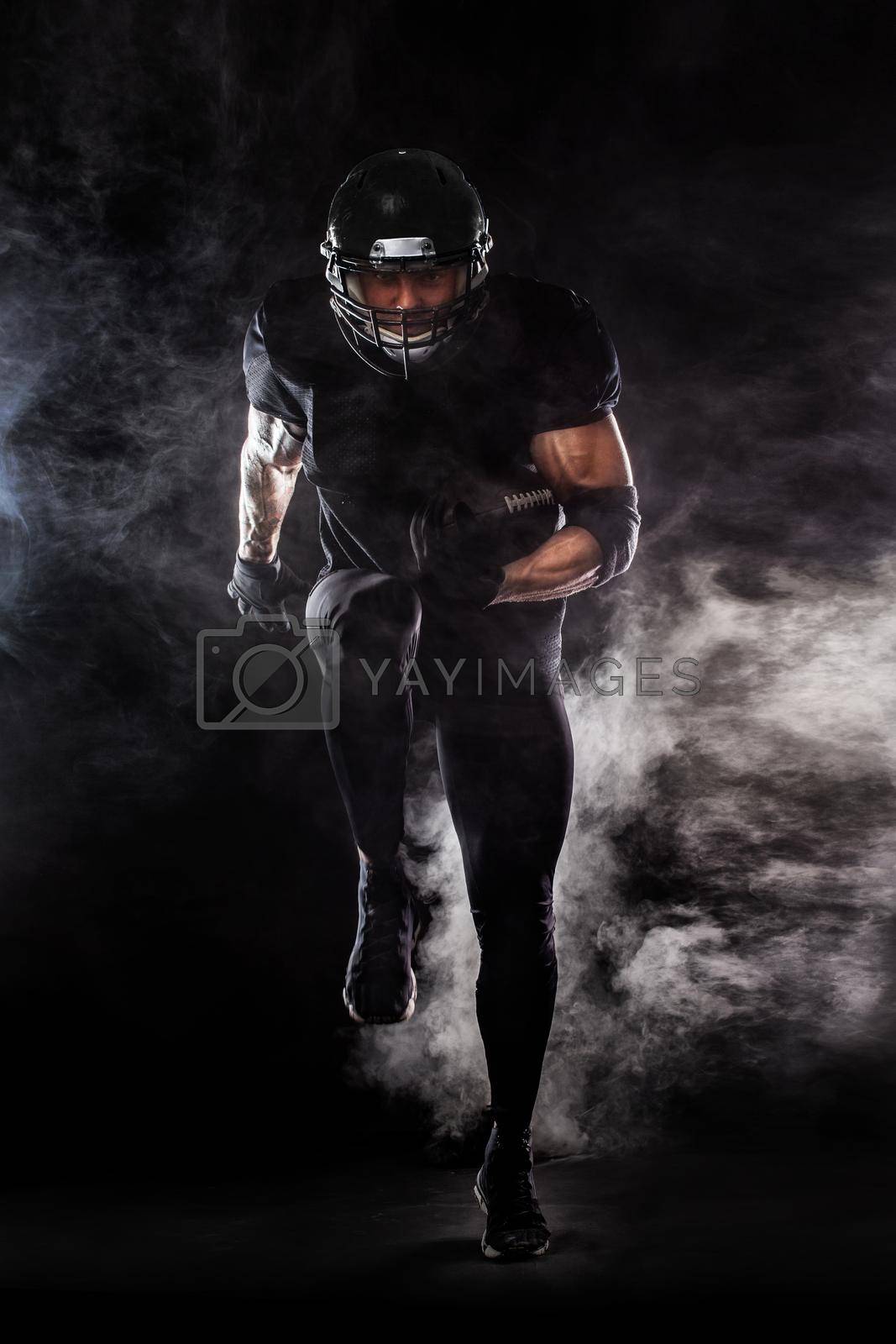 Royalty free image of American football sportsman player isolated on black background by MikeOrlov