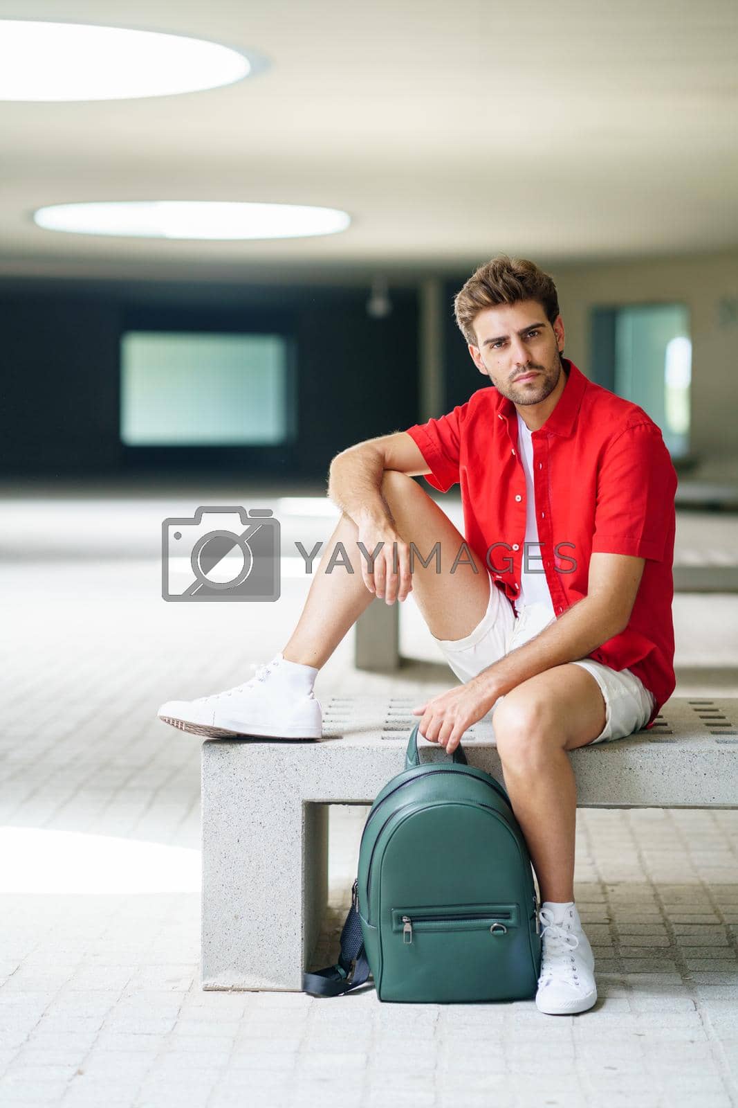 Royalty free image of Male student sitting on a college campus bench by javiindy