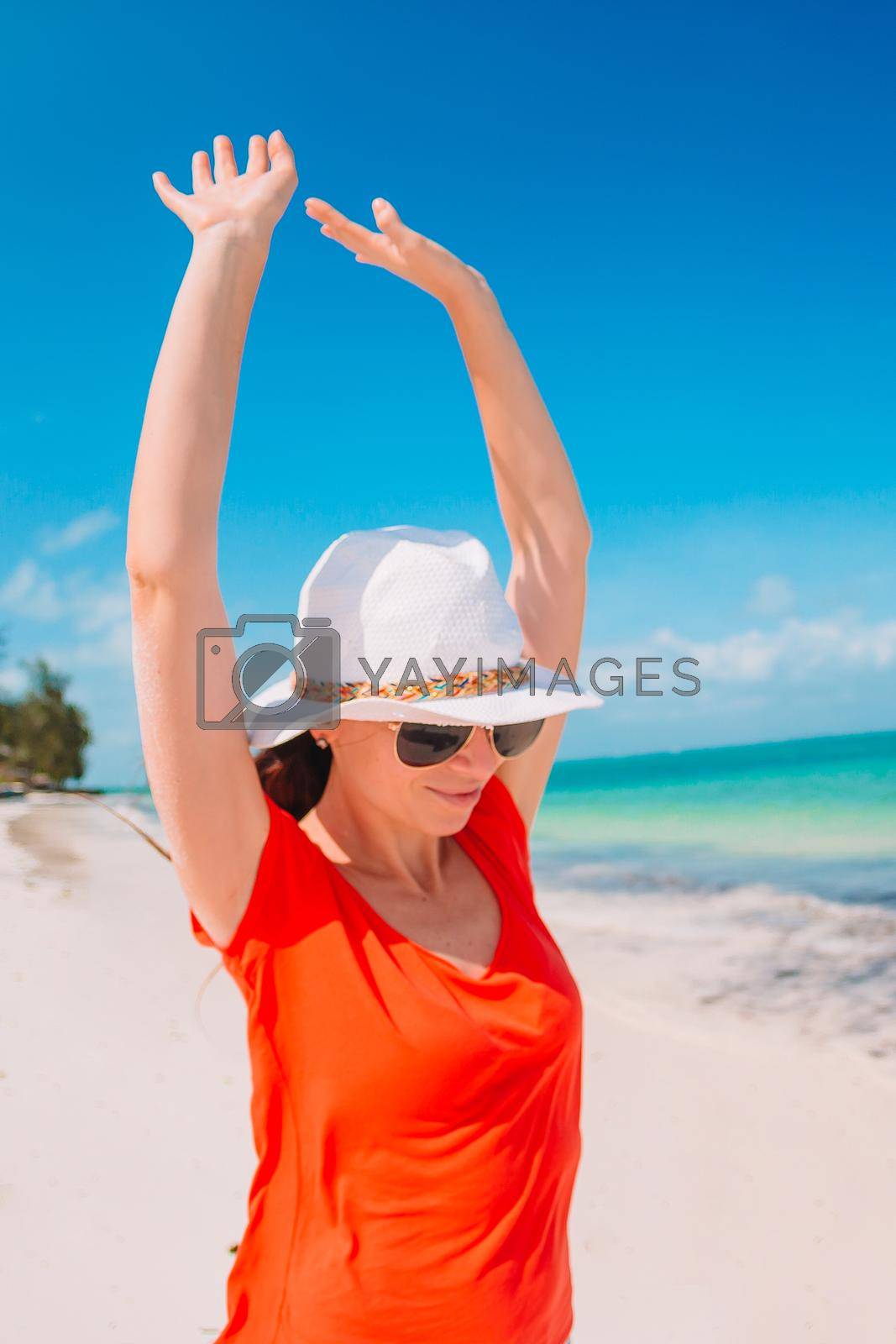 Young beautiful woman on white sand tropical beach.