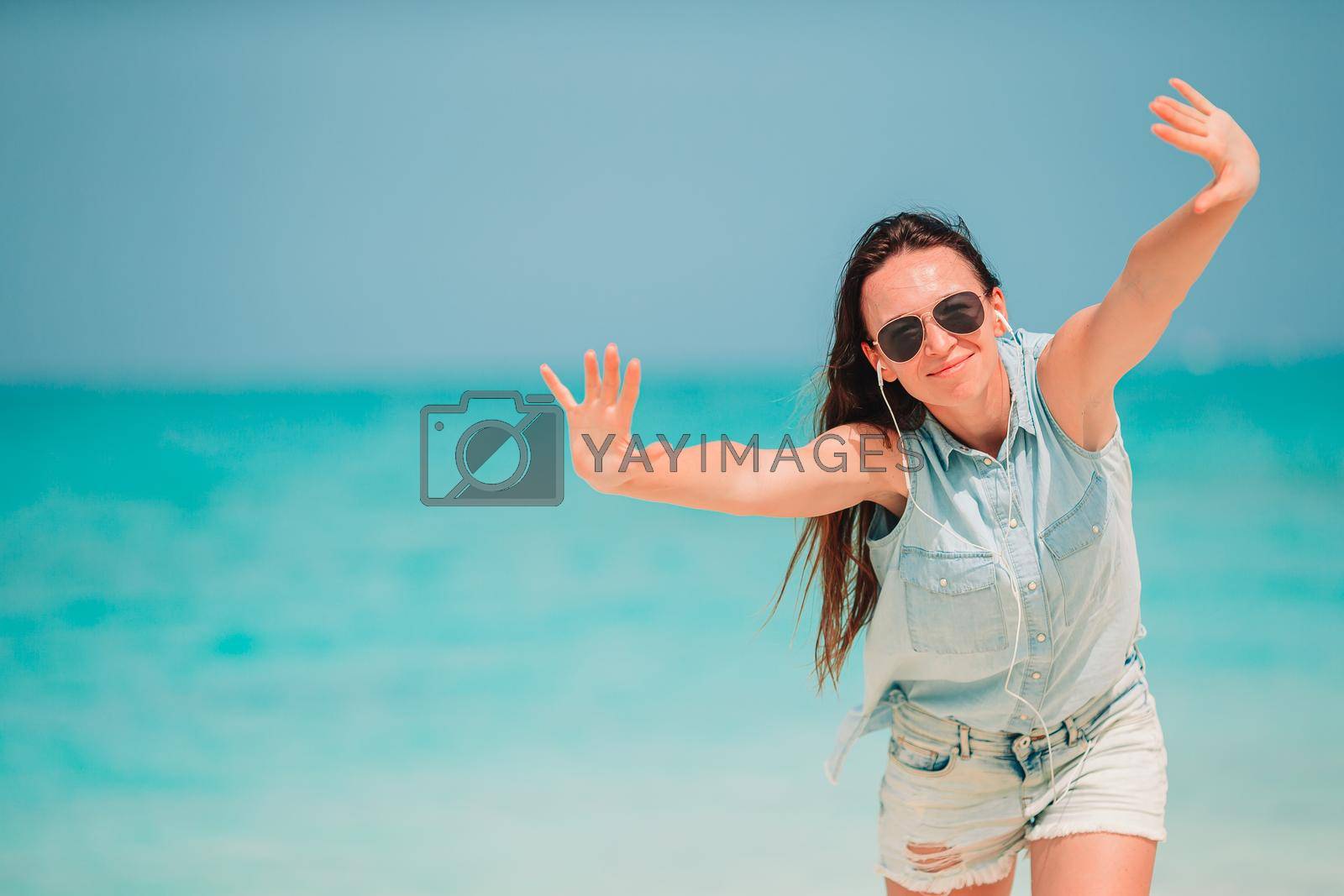 Young beautiful woman on white sand tropical beach.