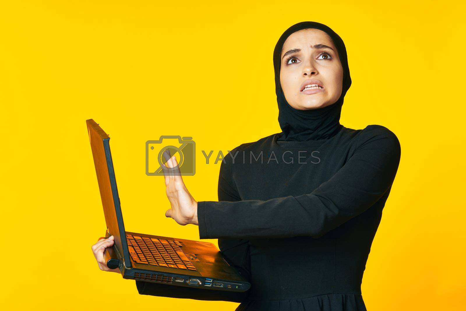 Royalty free image of pretty woman arab clothing laptop technology internet ethnicity model by Vichizh