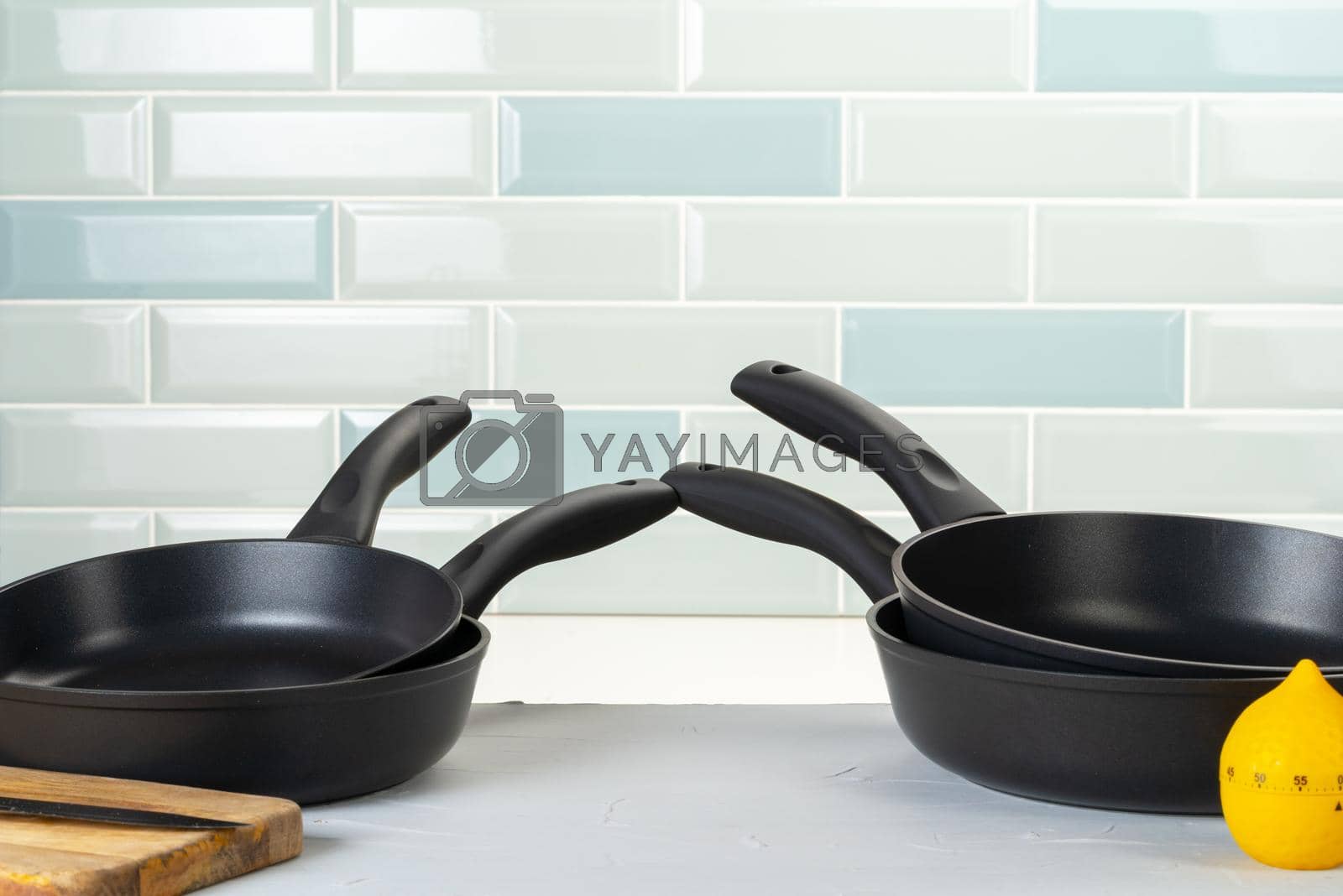 Royalty free image of Clean and dry cooking pans on a kitchen counter by Fabrikasimf