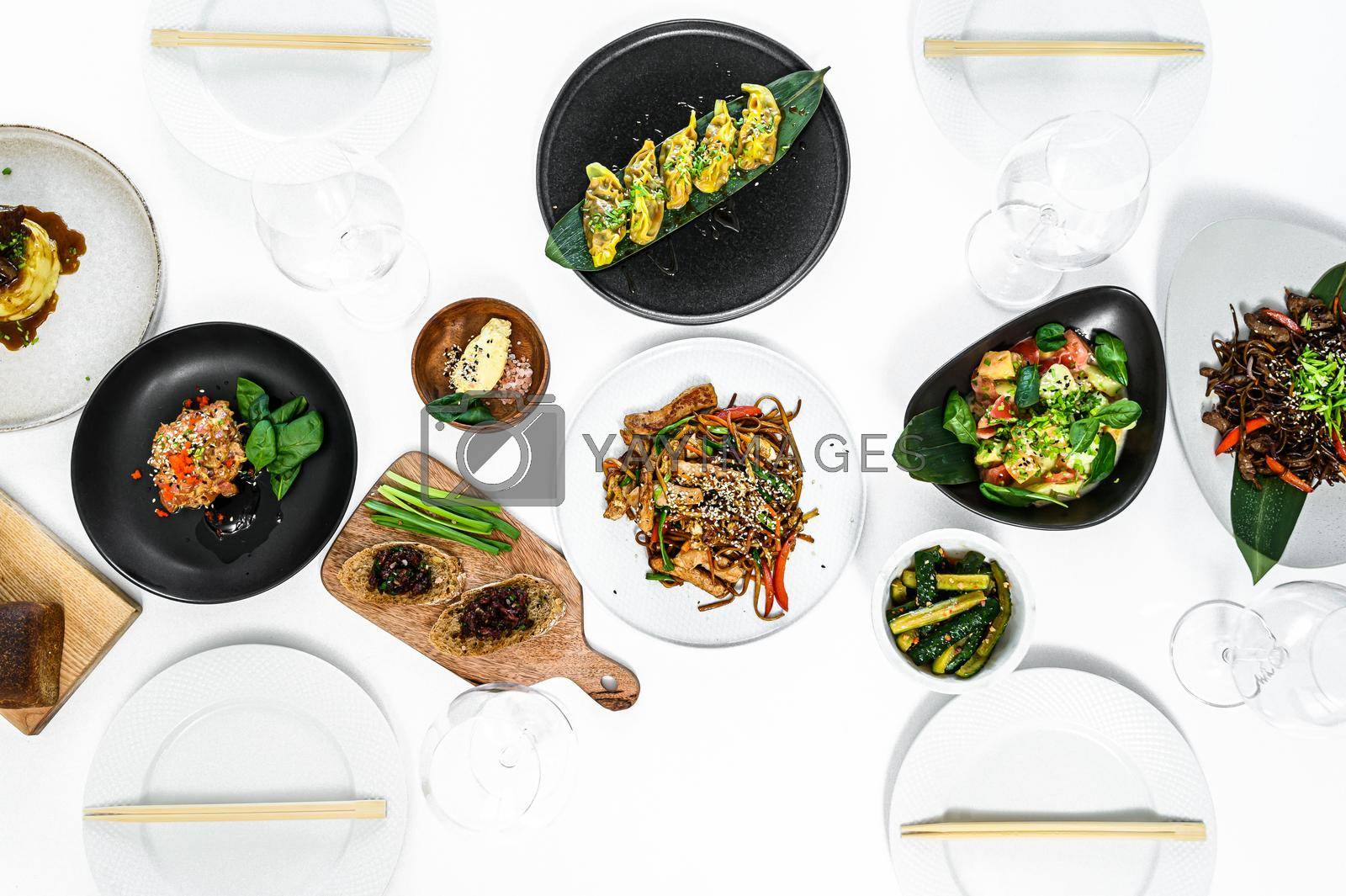 Asian food served on white table. Chinese and vietnamese cuisine set. Gray background. Top view.