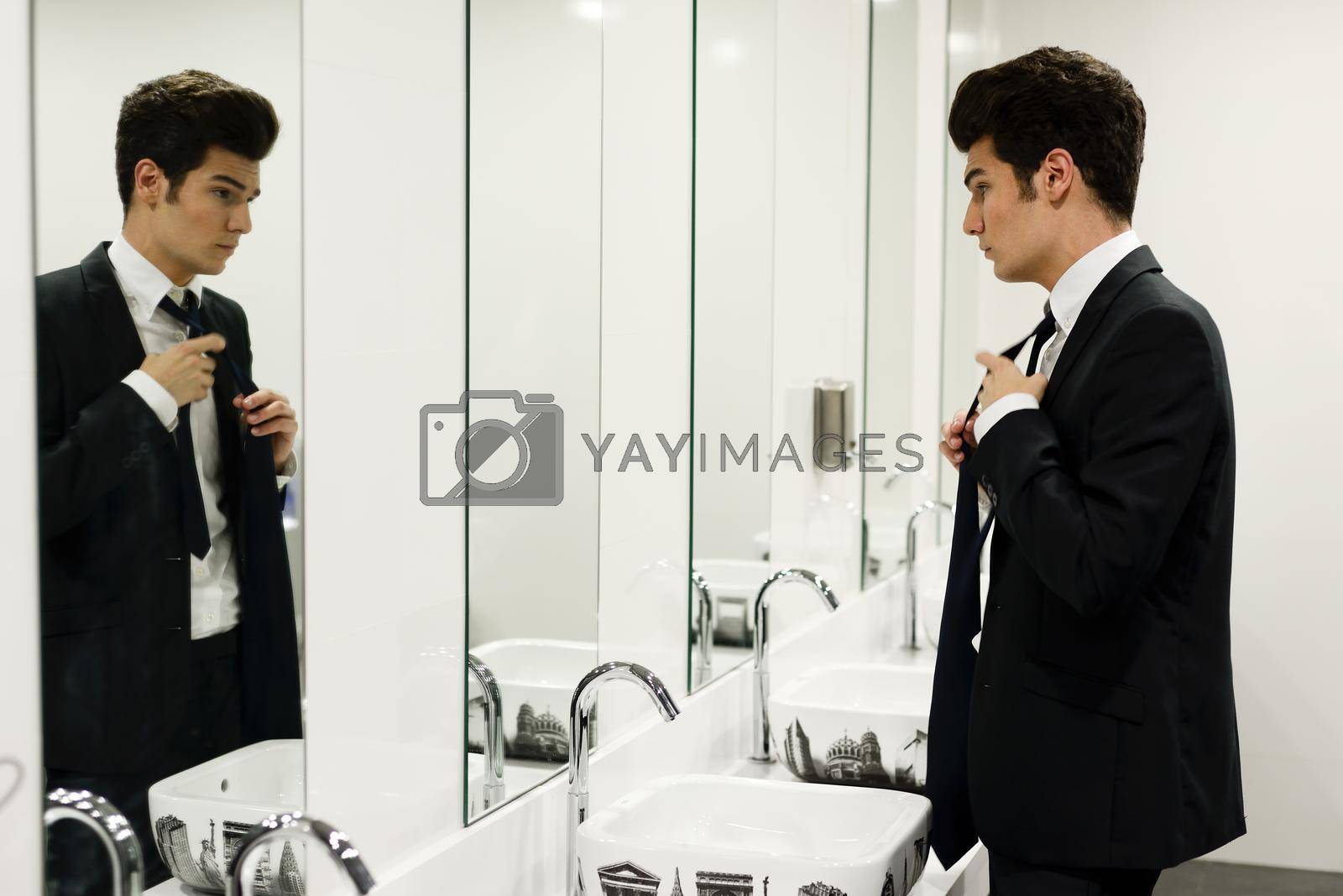Royalty free image of Man getting dressed in a public restroom with mirror by javiindy