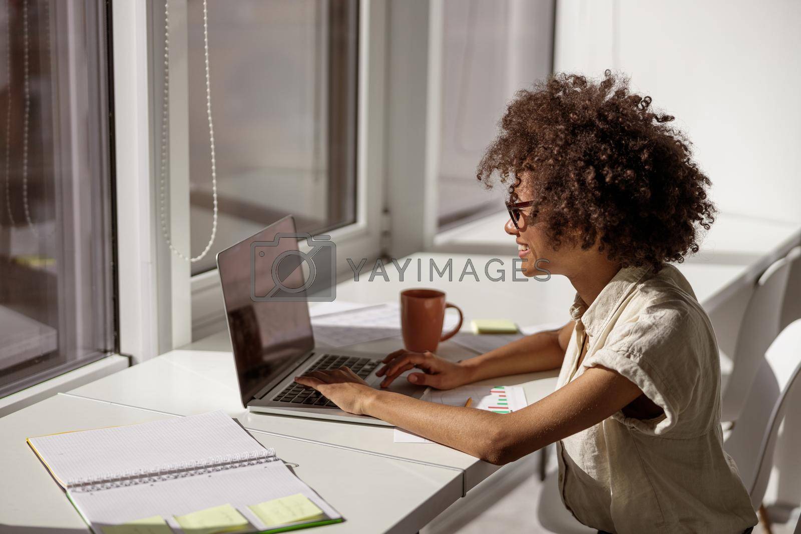 Royalty free image of African American woman concentrated looking at computer screen by Yaroslav_astakhov
