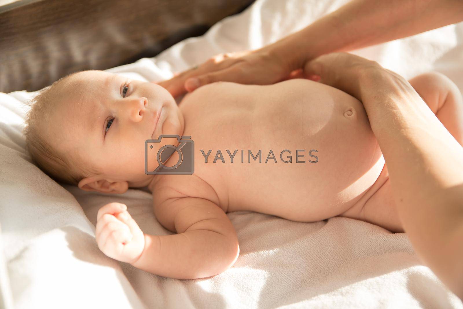 Royalty free image of A little baby lying on a bed on white sheets by Studia72