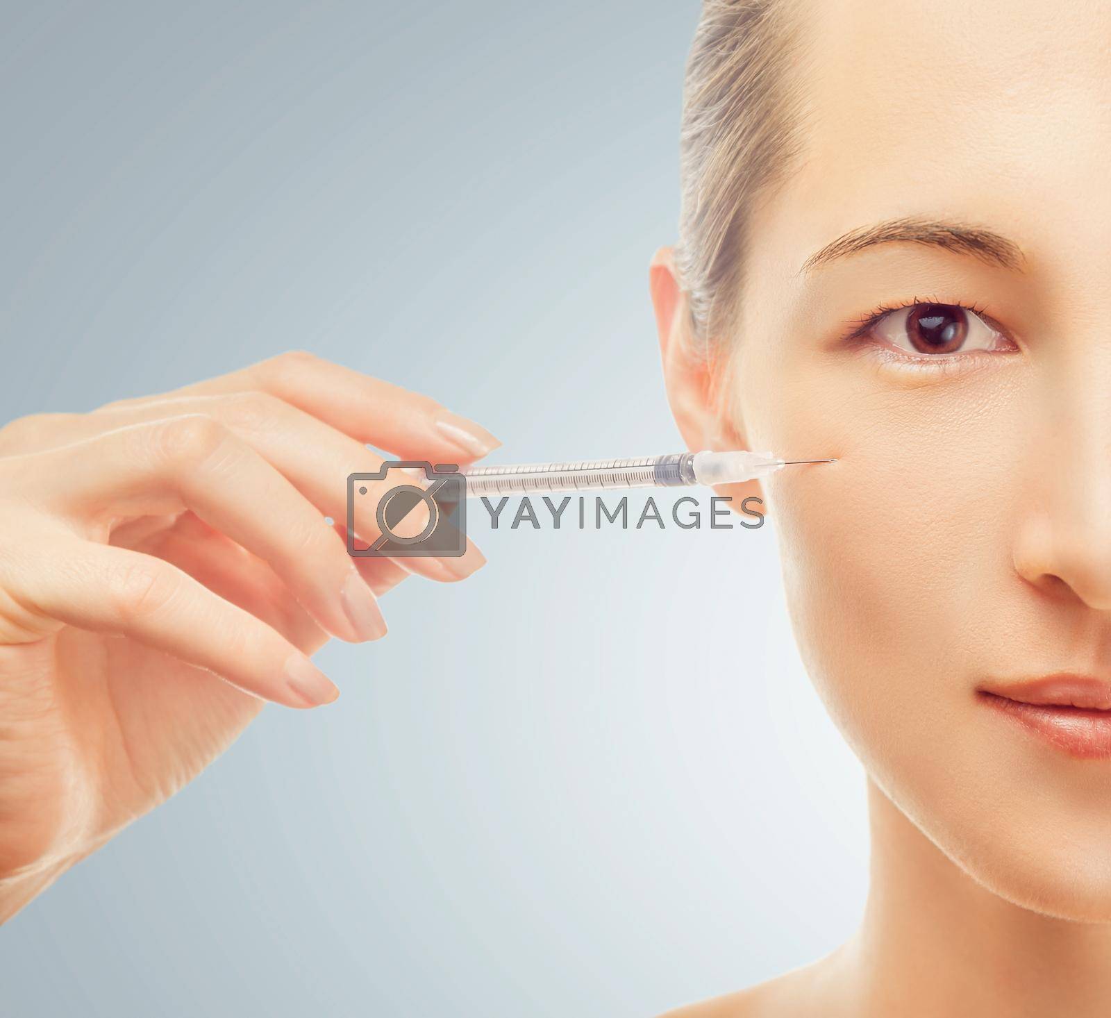 Royalty free image of Syringe near the woman's face, beauty concept by alexAleksei
