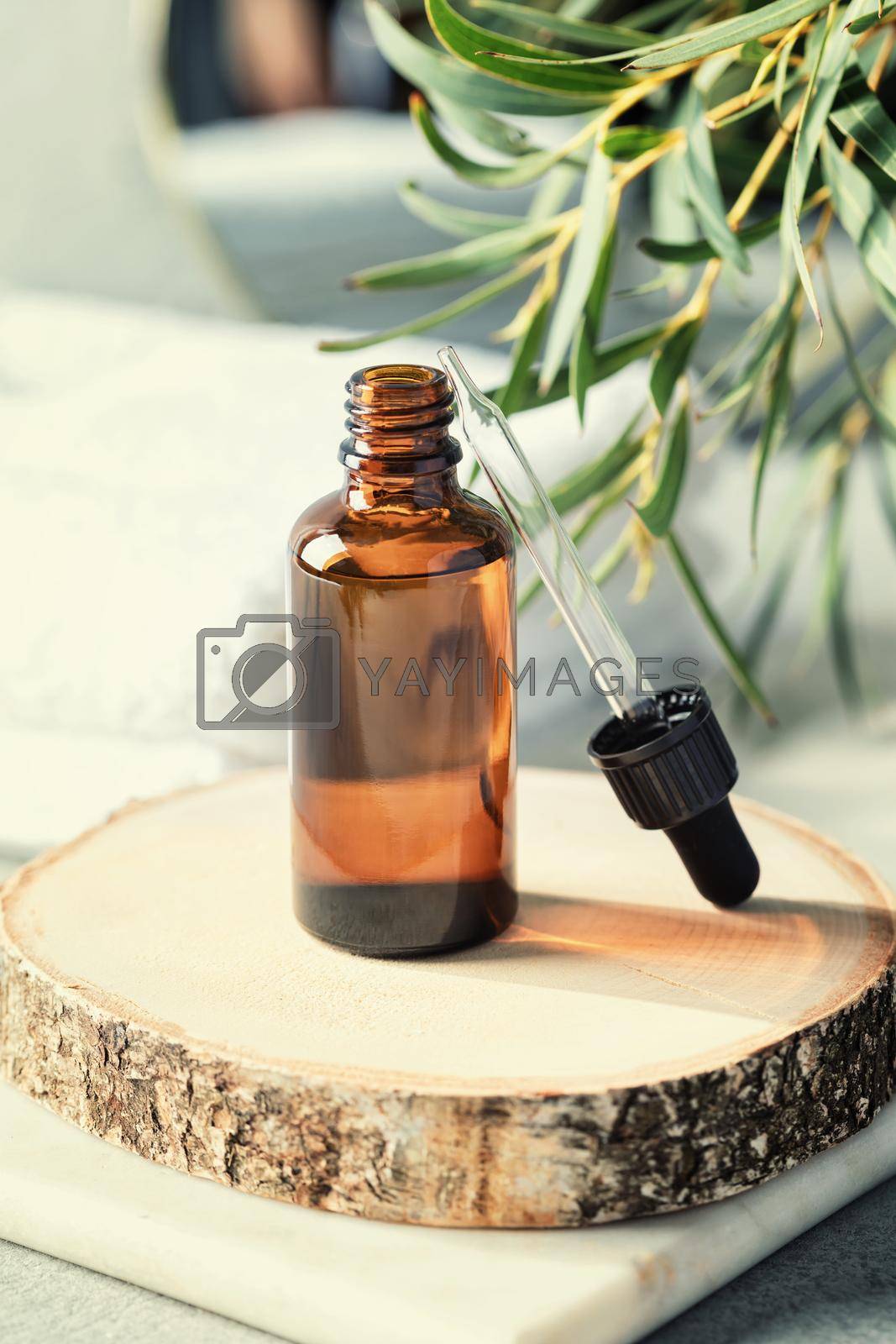 Amber glass bottle with eucalyptus leaves and towels. Natural organic cosmetic packaging, luxury beauty products for body care