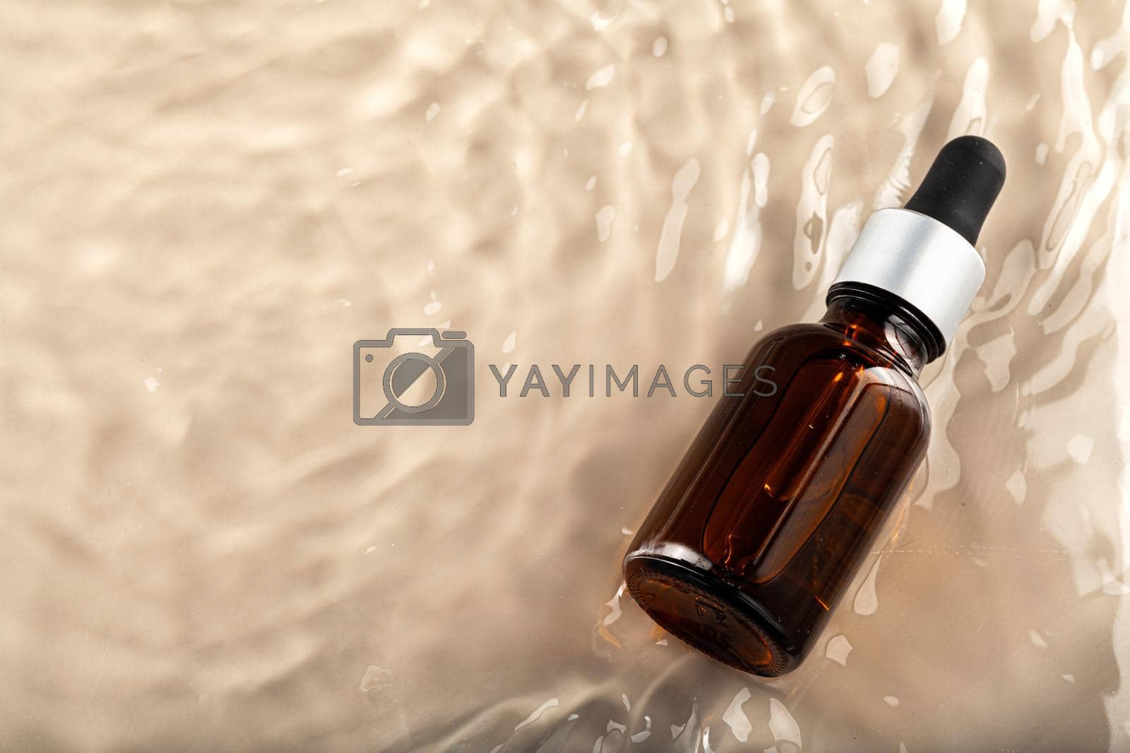 Royalty free image of Cosmetic bottle with pipette in wavy water by Fabrikasimf