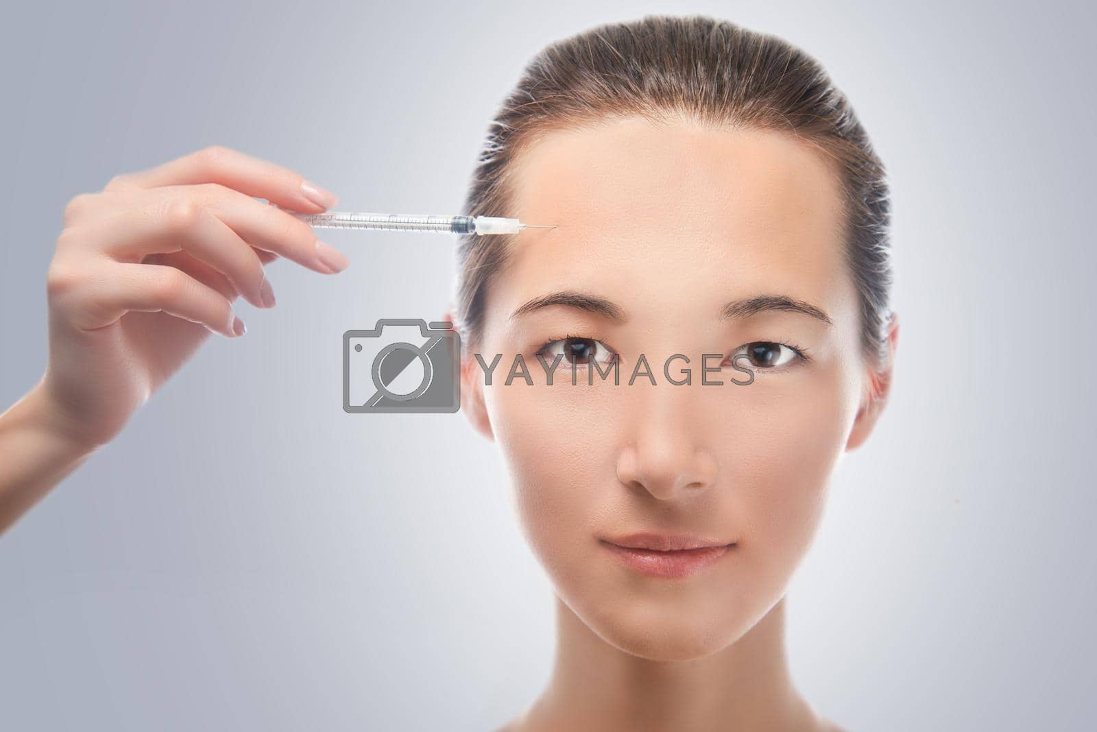 Portrait of a beautiful woman, injection of a cosmetic product in facial skin