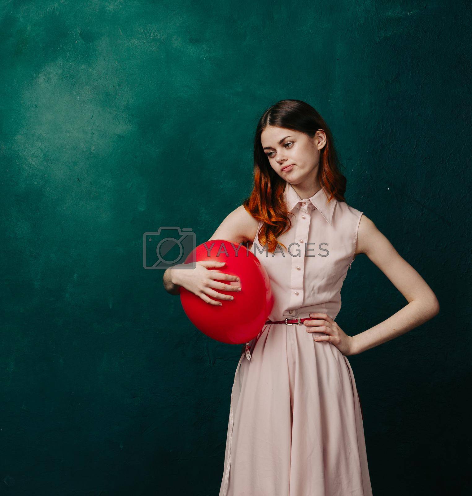 woman with red balloon celebration birthday green background. High quality photo