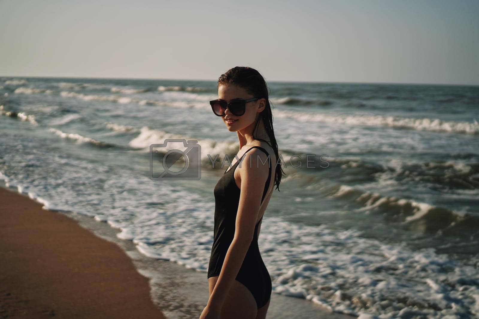 cheerful woman in black swimsuit sunglasses beach walk travel. High quality photo