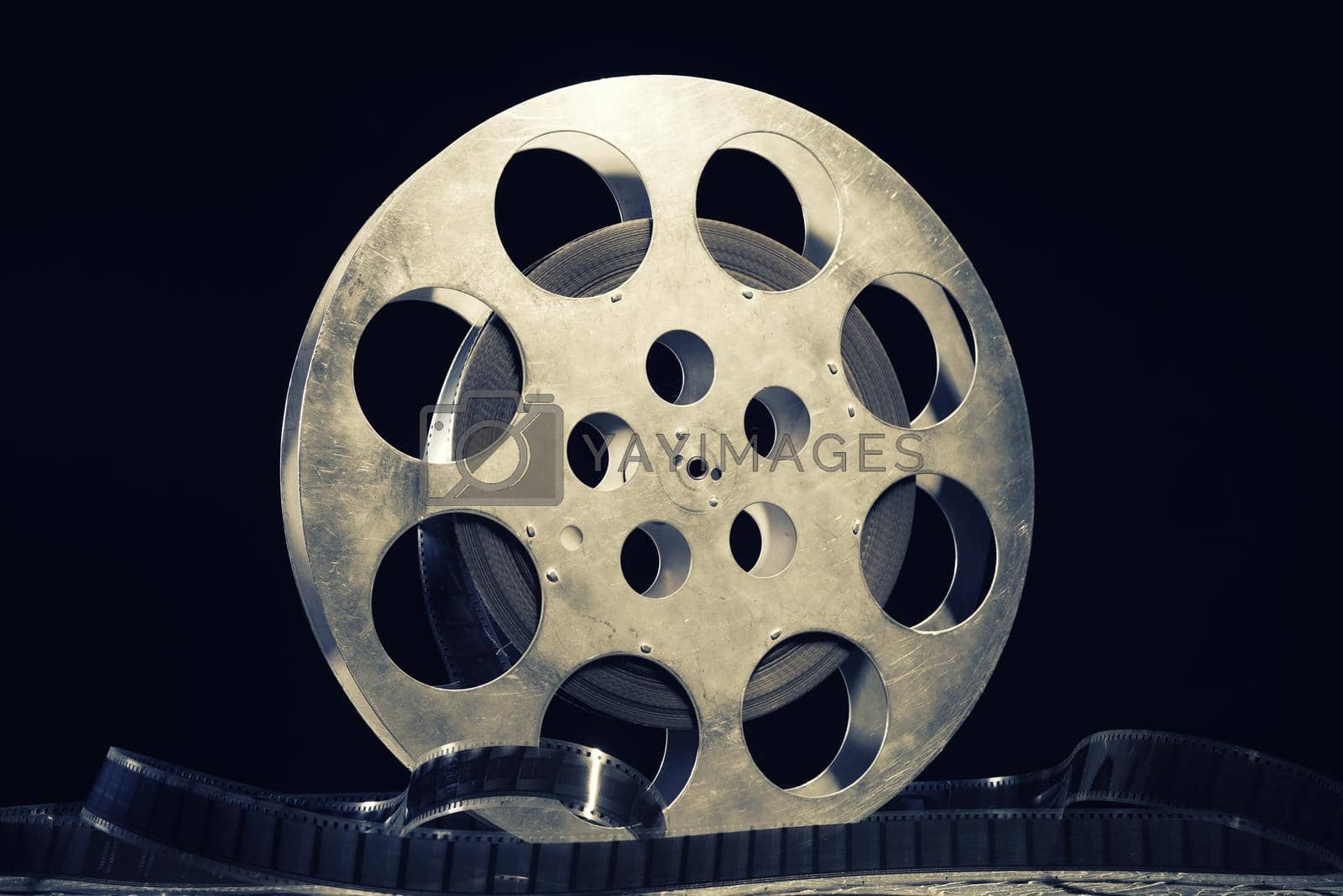 Royalty free image of 35 mm film reel with dramatic lighting on a dark background by zartarn