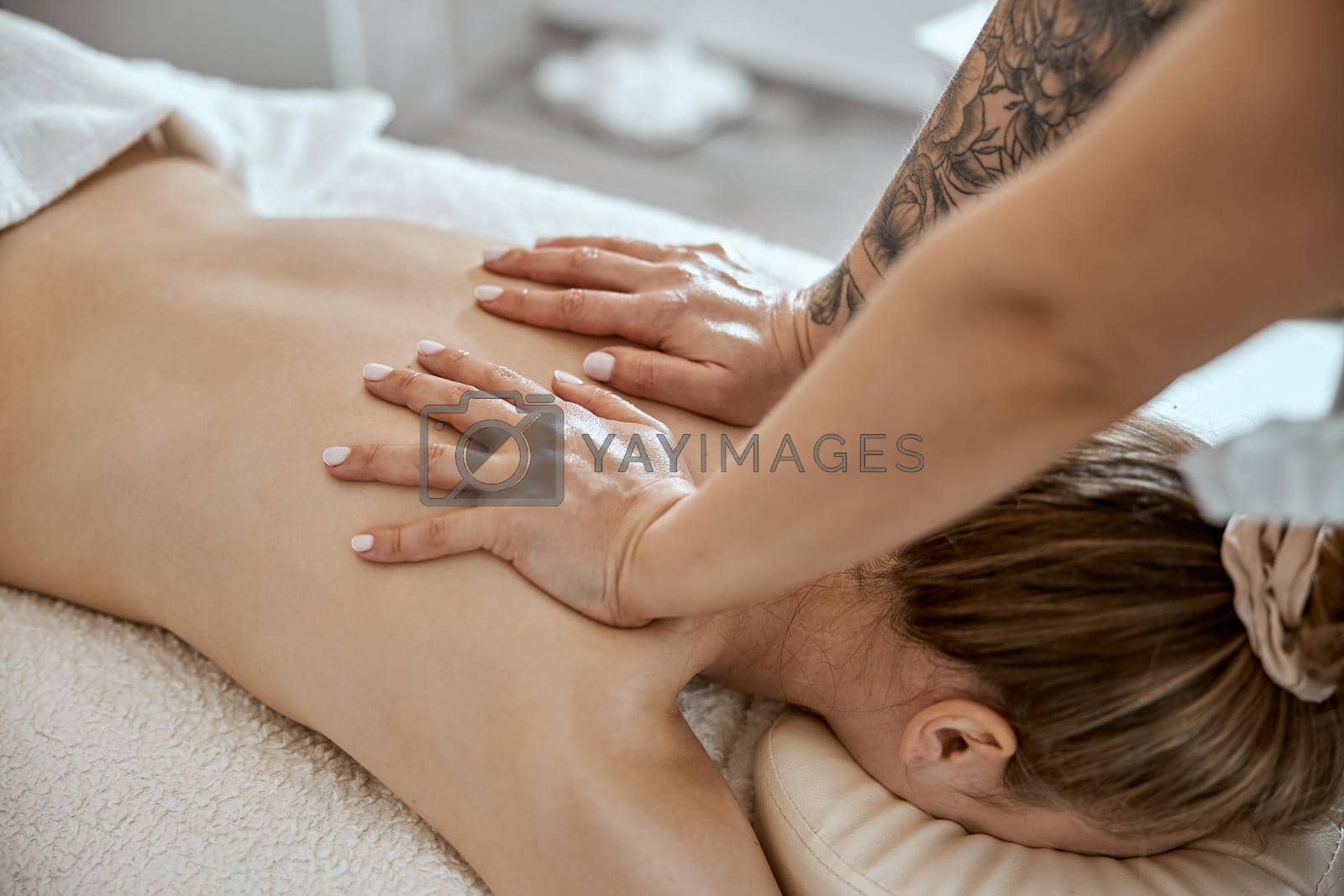 Royalty free image of Professional confident massage master is doing procedures to caucasian woman in minimalistic modern cabinet by Yaroslav_astakhov