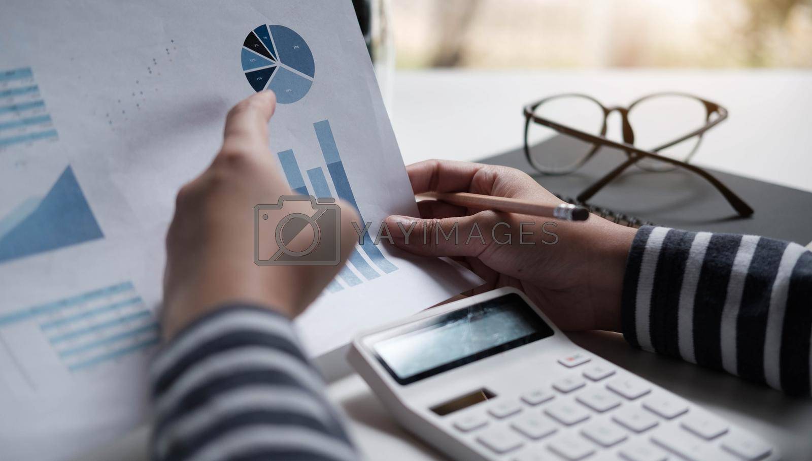 Business women reviewing data in financial charts and graphs.
