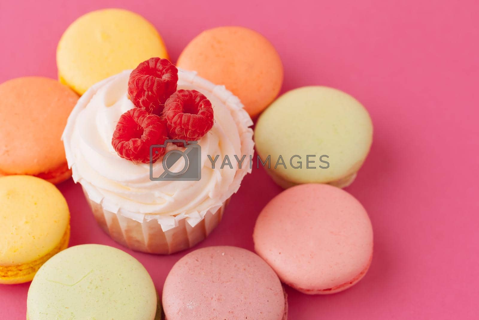 Royalty free image of Yummy sweet cupcakes on light pink background by Fabrikasimf