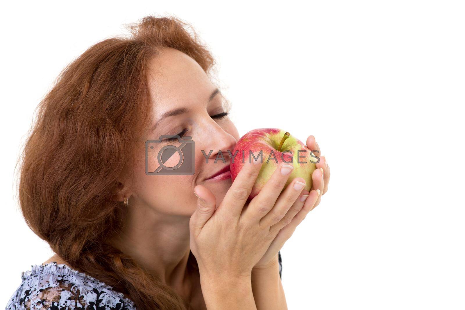 Royalty free image of Beautiful woman smelling fresh red apple by kolesnikov_studio