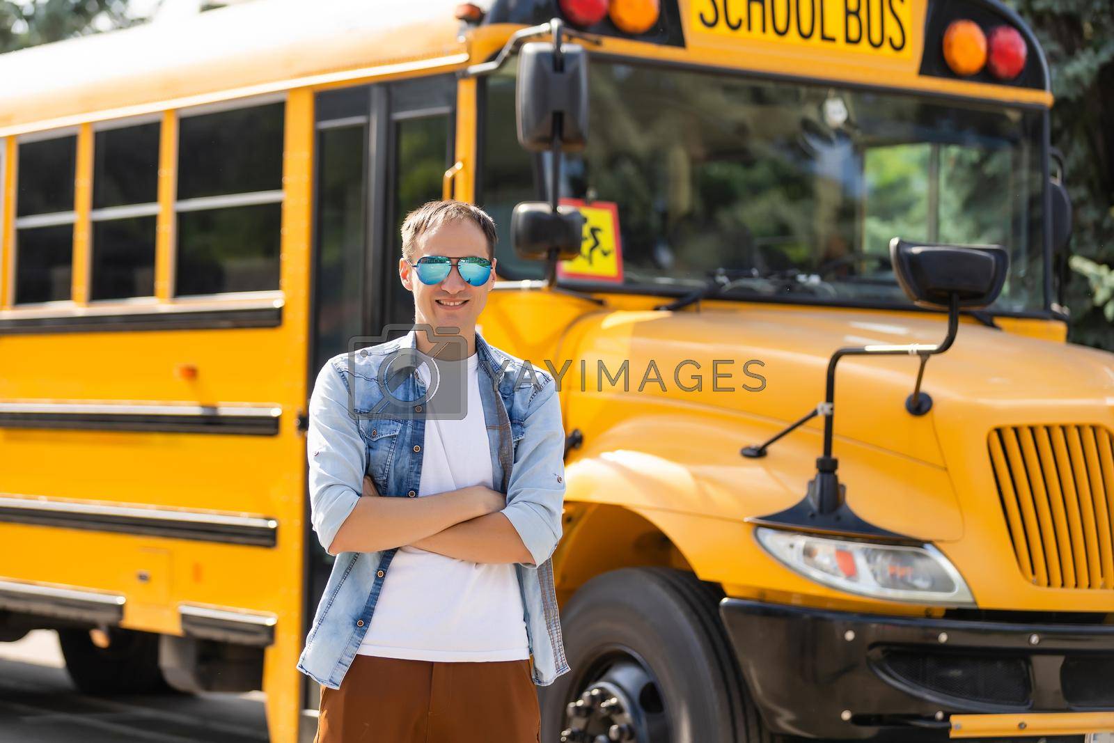 Portrait of smiling teacher near school bus