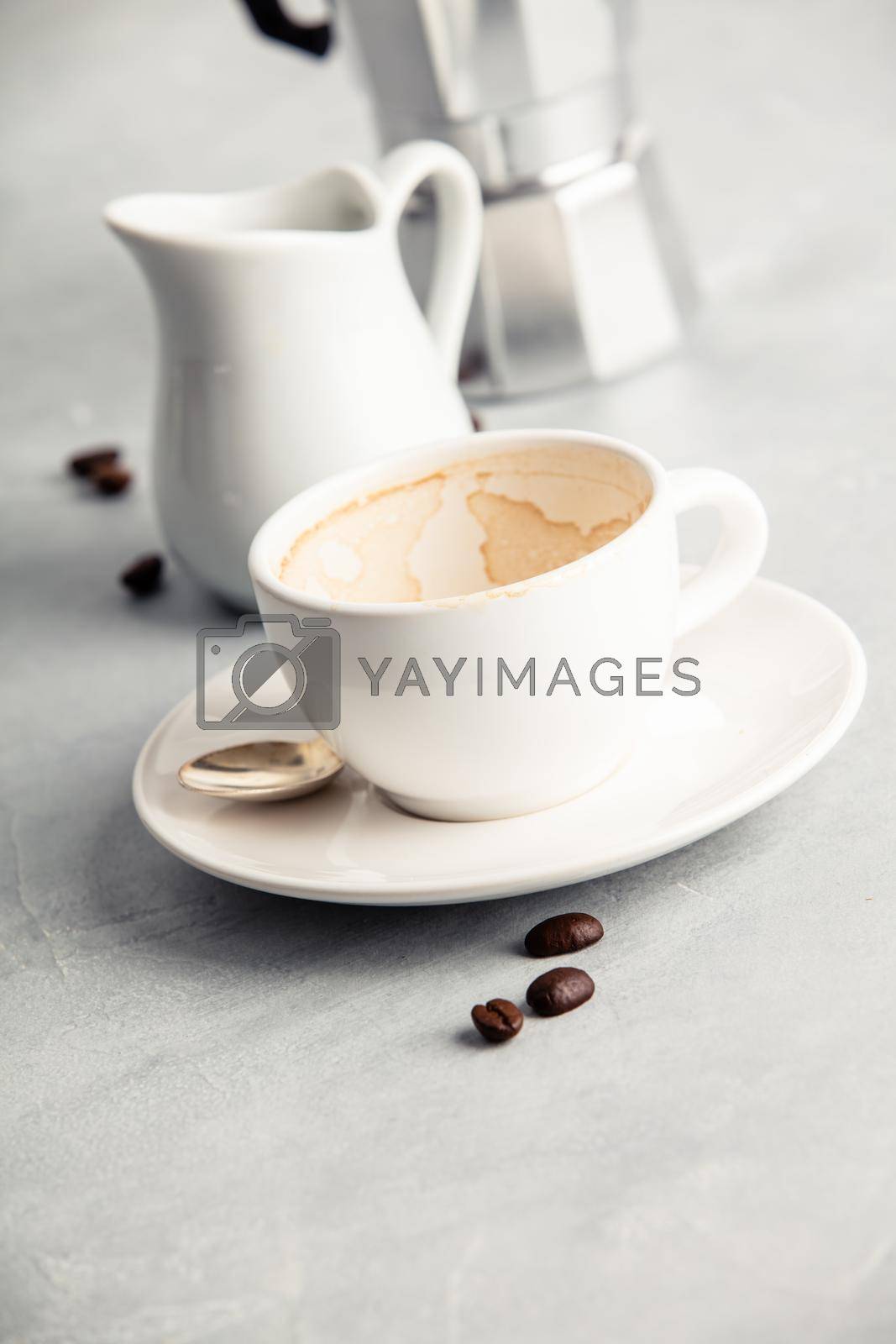 Empty coffee cup after drink with coffee maker and milk on concrete background, close up