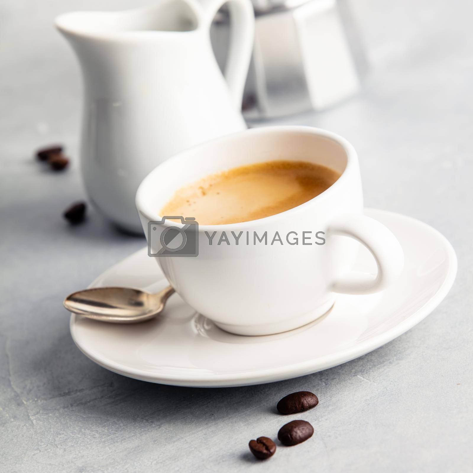Royalty free image of Coffee espresso in white cup with milk and coffee maker by klenova