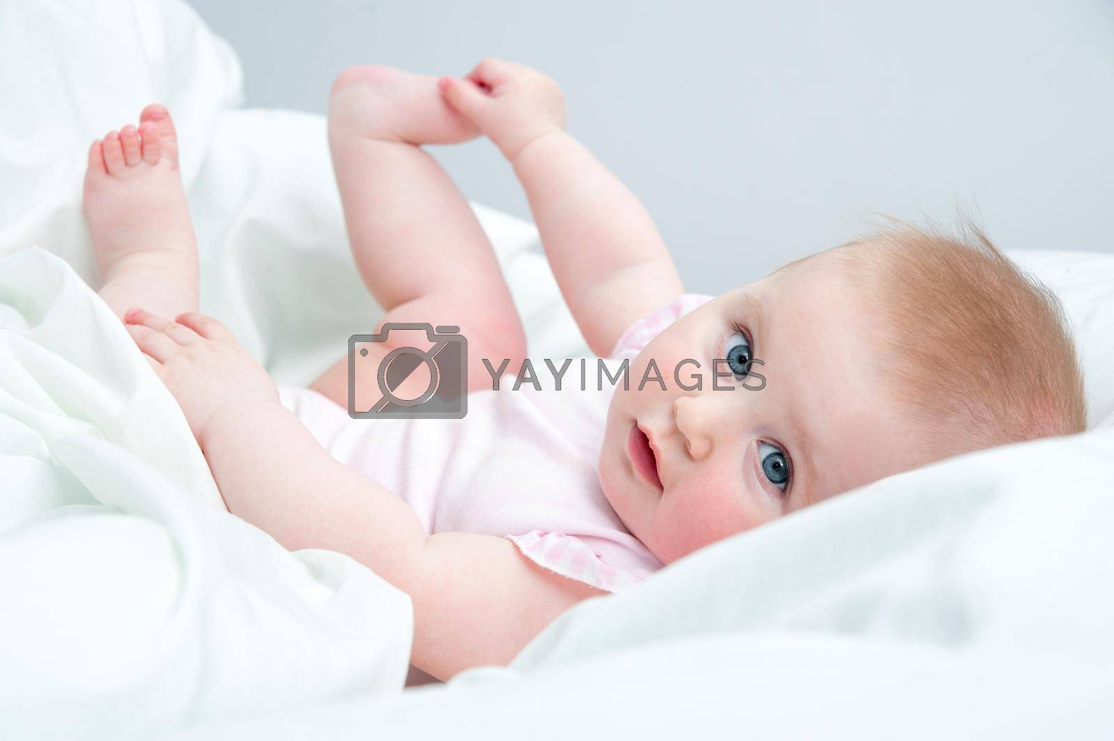 Royalty free image of baby playing with his feet by tan4ikk1