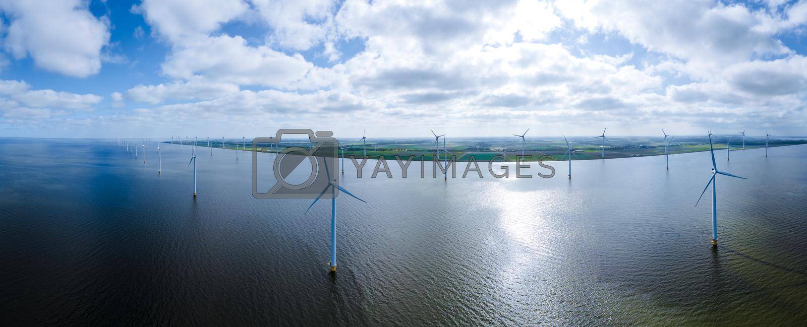 Royalty free image of offshore windmill park with clouds and a blue sky, windmill park in the ocean drone aerial view with wind turbine Flevoland Netherlands Ijsselmeer by fokkebok