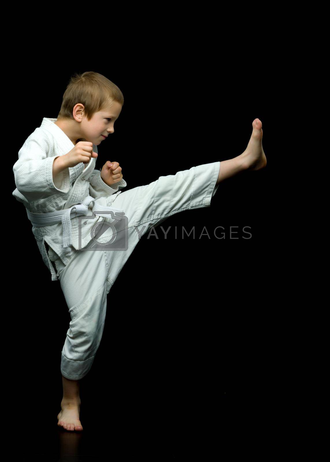 Royalty free image of A little boy in a white kimono fulfills blows by kolesnikov_studio