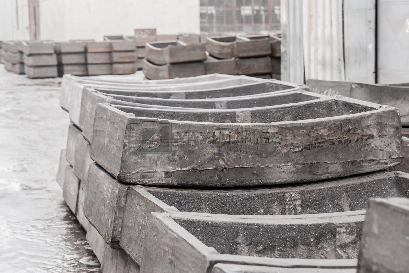 Royalty free image of Cast iron tubing reinforced concrete cast products for lining distillation tunnels and underground structures are stored in the warehouse of the industrial plant by AYDO8