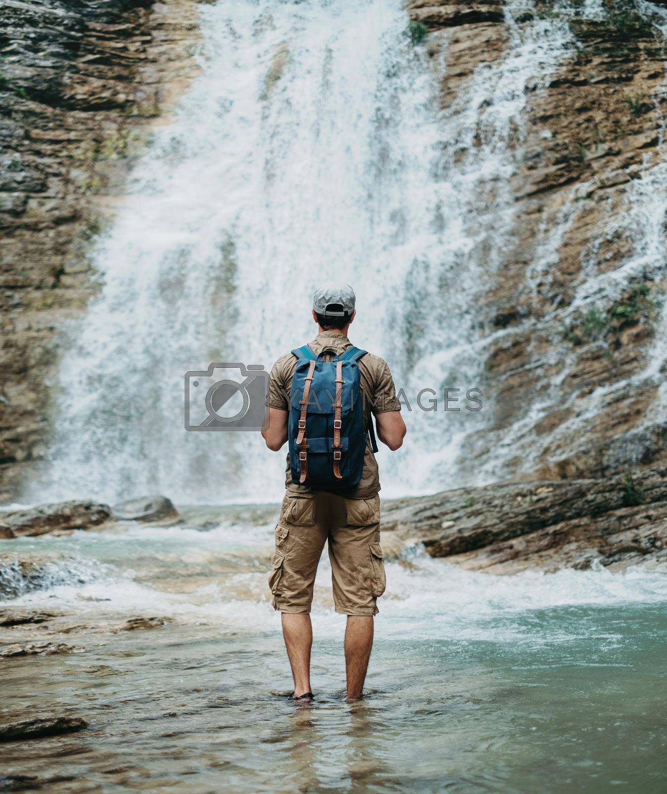 Royalty free image of Explorer man looking at waterfall by alexAleksei