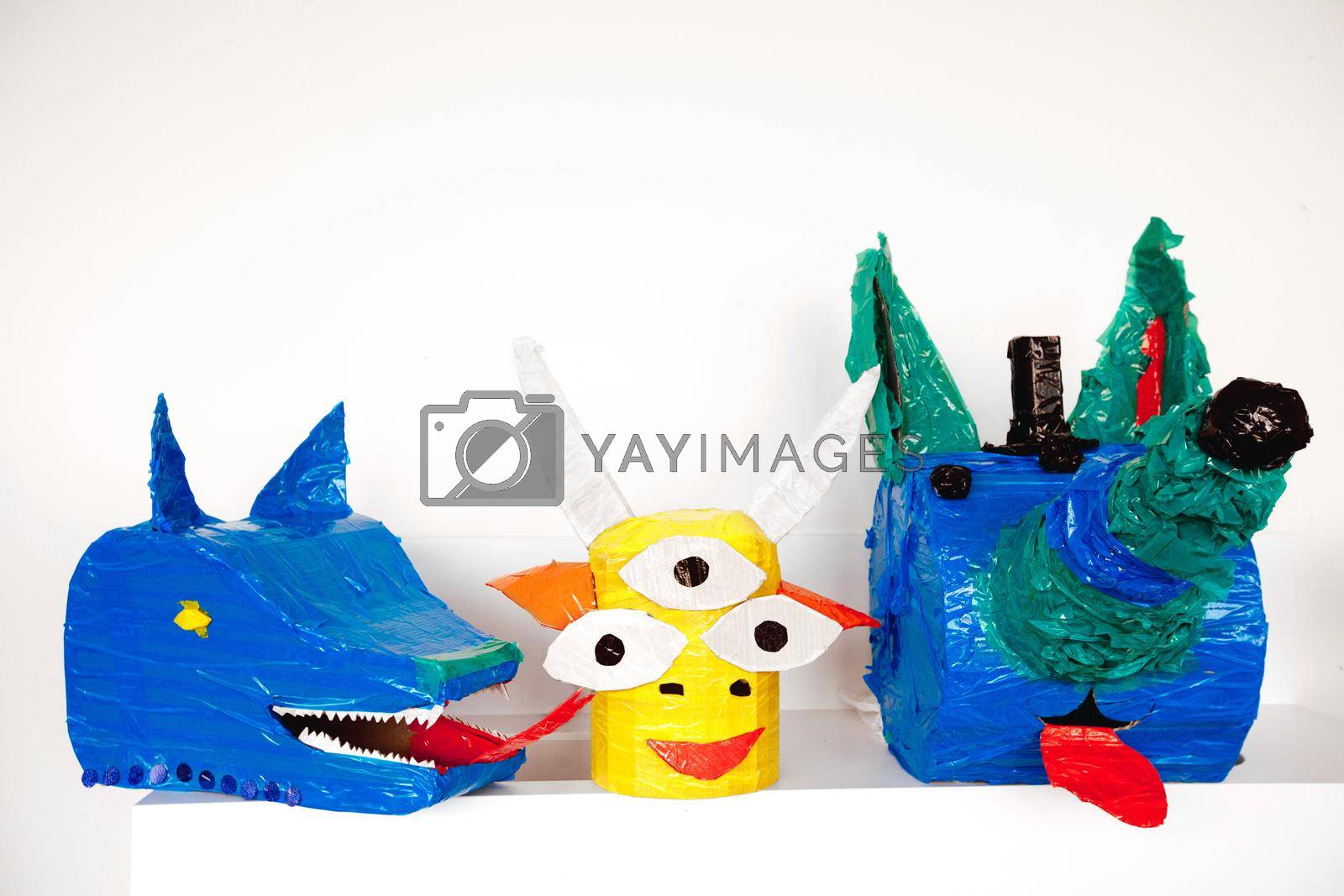 Colorful artistic heads of fantastic animals made with carton and tape composed in set.