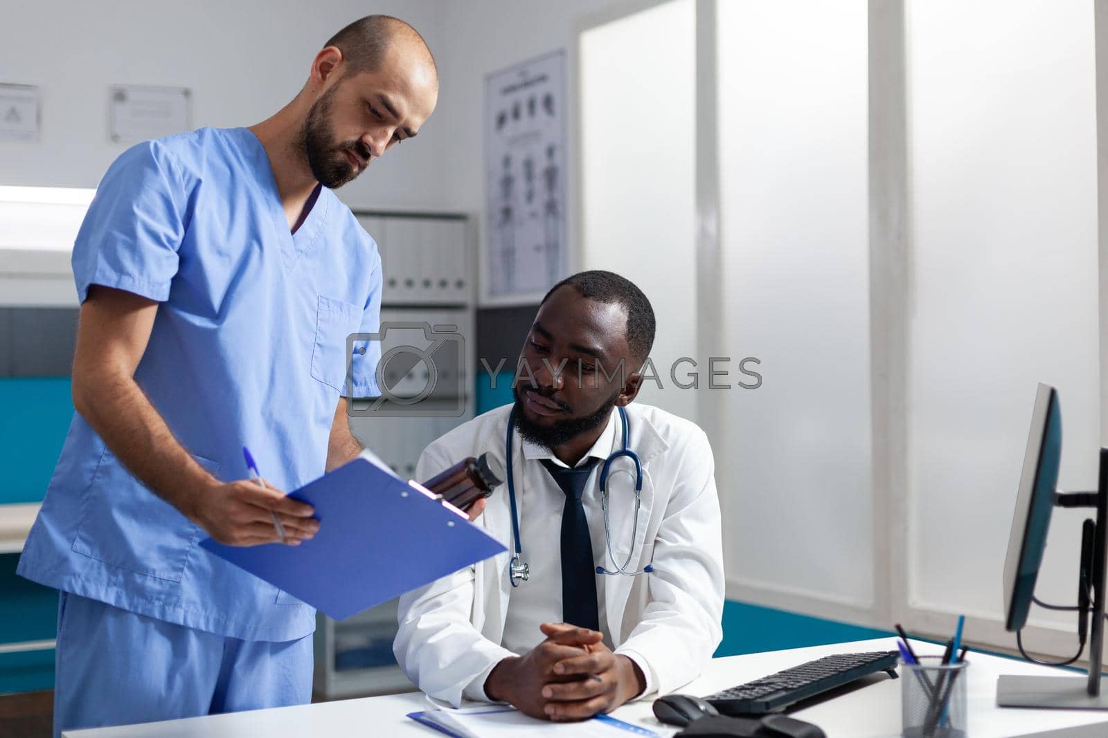 Medical team of practitioners analyzing disease symptoms discussing healthcare treatment working in hospital office. Doctor checking medicine prescription during clinical appointment