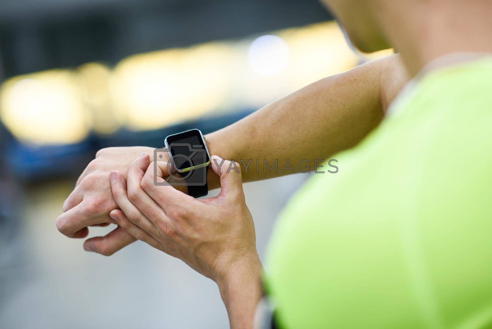 Royalty free image of Young man using smartwatch at the gym by javiindy