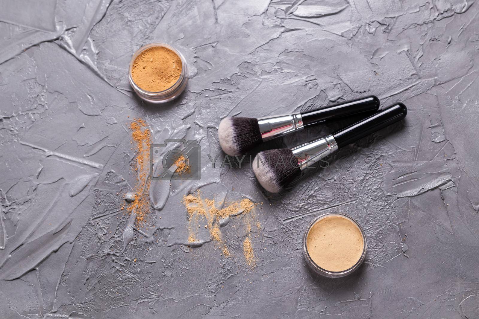 Royalty free image of Loose compact mineral powder for face and a brushes for powder and visage on stone background. Eco friendly and organic cosmetics. by Satura86