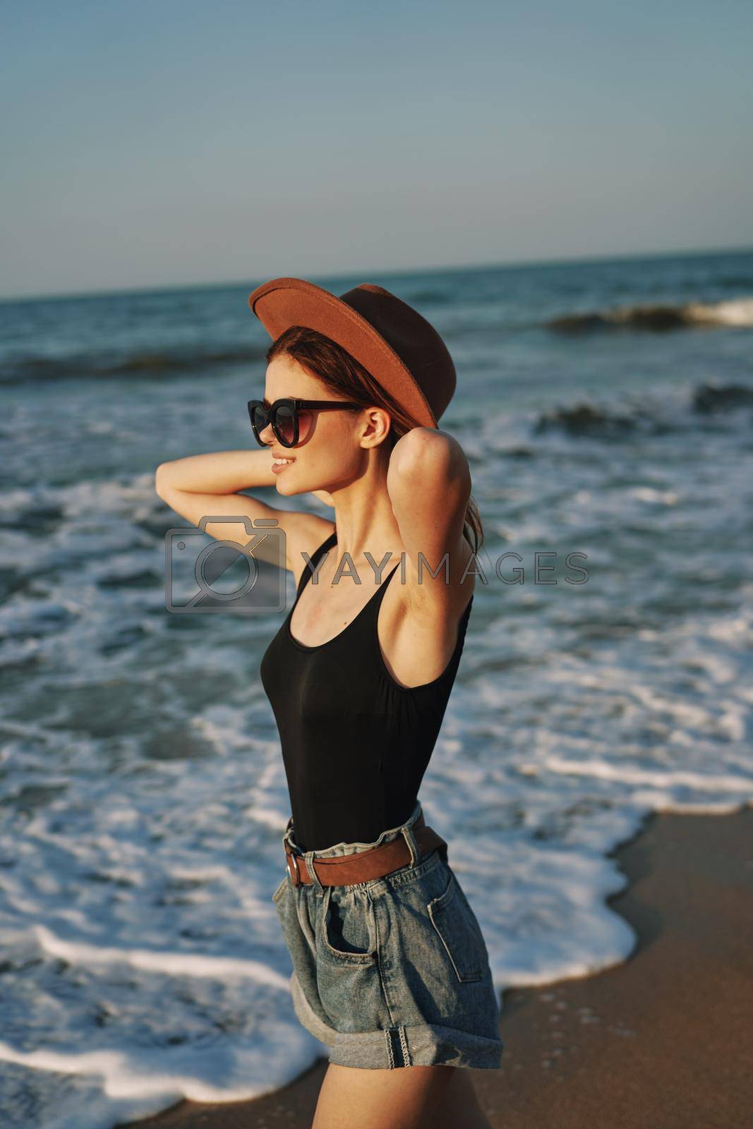 woman walking on the beach hat travel vacation sun. High quality photo
