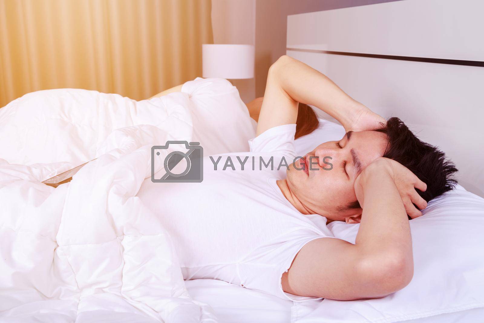 Royalty free image of man having sleepless on bed and having migraine,stress, insomnia, hangover in bedroom by geargodz
