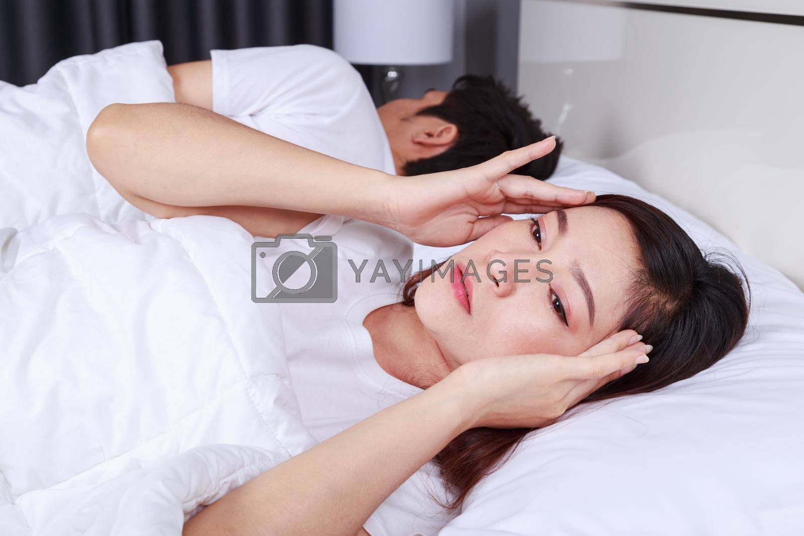 Royalty free image of woman having sleepless on bed and having migraine,stress, insomnia, hangover in bedroom by geargodz