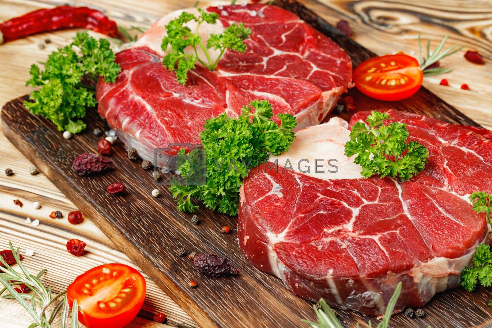 Royalty free image of Raw meat slice for grill with seasoning by Fabrikasimf